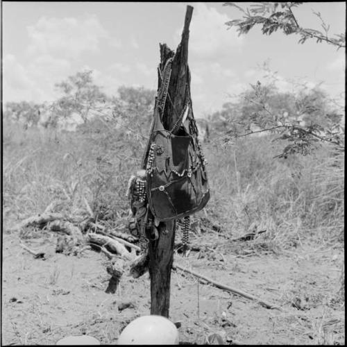 Beaded hunting sack with Western buttons hanging on a post with strings of beads and two tortoise shells