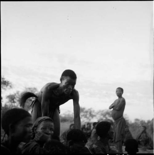 /Ti!kay leaning over, curing people sitting at a daytime dance