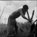 Man skinning the leg of a dead wildebeeste