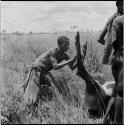 Man working on the hind leg of a dead wildebeeste