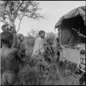 Men and boys standing at the back of the expedition Jeep