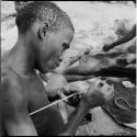 Man applying poison to an arrow, close-up