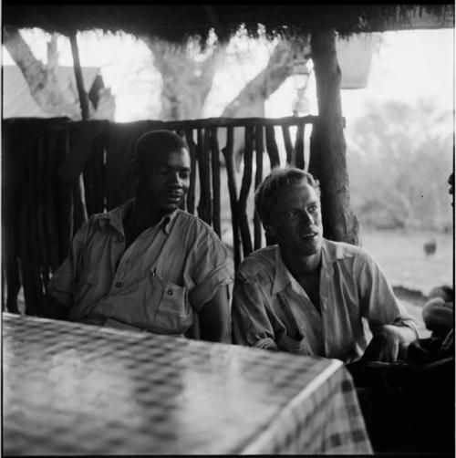 Wilhelm Camm and John Marshall sitting at a table in the expedition camp