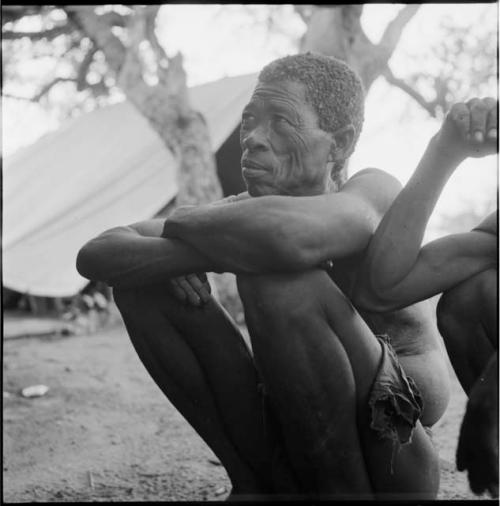 Gau sitting, with an expedition tent in the background