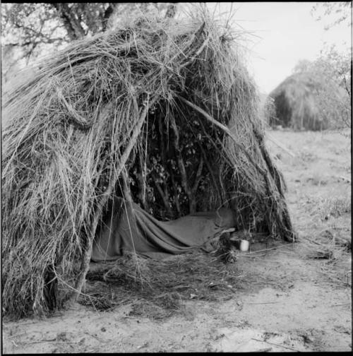 Person sleeping under a blanket in a skerm