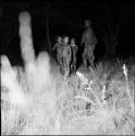 Three children standing, with a woman dancing next to them, at a night dance