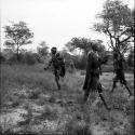 Two women playing tamah n!o’an (ball game), one carrying a baby on her back