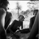 Group of boys playing /Ui (the counting game) in the sand