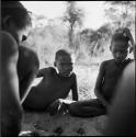 Group of boys playing /Ui (the counting game) in the sand