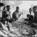 Group of boys playing /Ui (the counting game) in the sand