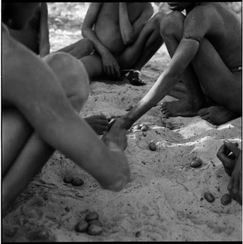 Group of boys playing /Ui (the counting game) in the sand, close-up