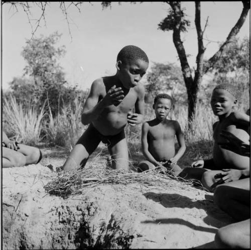 Boys playing !ó'm!hú / !’Om g!xuni / ’Ai kota !U!u g!xuni / N!aih //’an (the porcupine game, also known as the axe game, assegai game or war game)