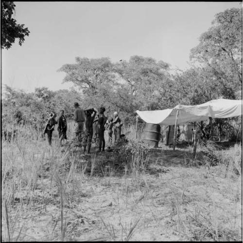 Group of people standing next to the expedition rain-saver, distant view