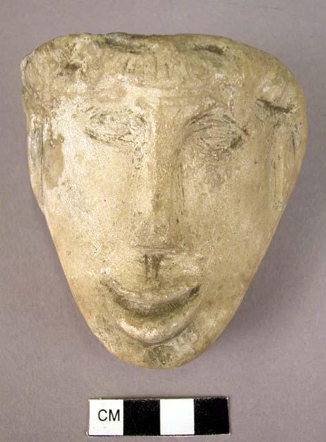 Carved stone, human face