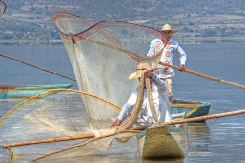 "Two butterfly net fishermen on Lago Patzcuaro, with nets held up"