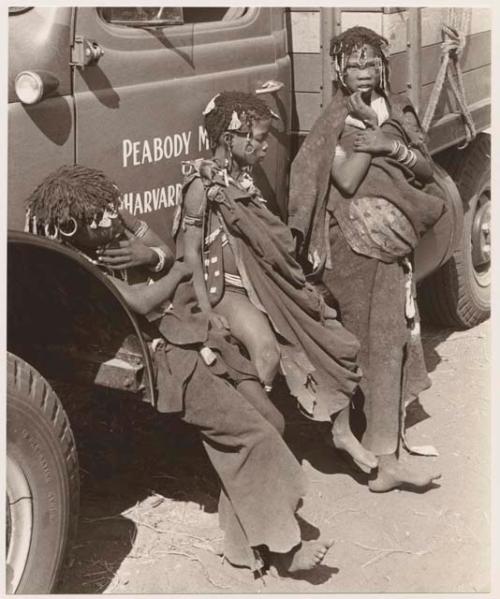 "Little N!ai" (left) and two unidentified girls leaning against an expedition truck