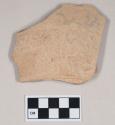 Coarse red bodied earthenware body sherd, with buff slip and incised lines