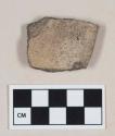 Coarse gray bodied earthenware rim sherd, with buff slip