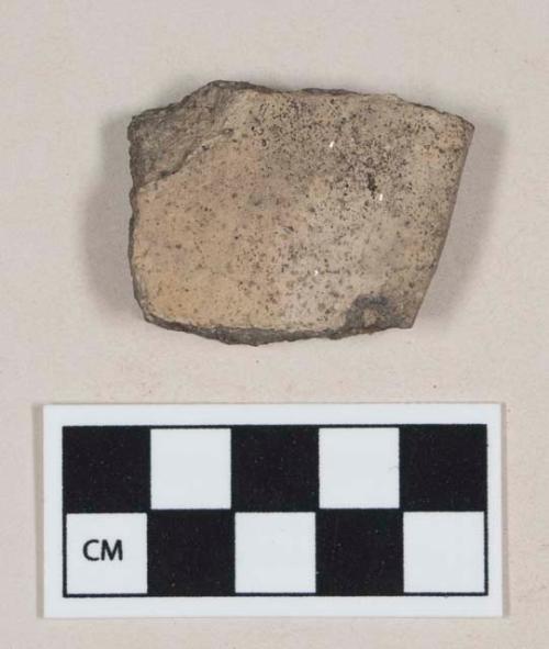 Coarse gray bodied earthenware rim sherd, with buff slip