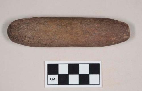 Ground stone tool, sharp edge on one end, possible pounding surface on the other end