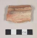Red bodied earthenware rim sherd, with red and buff slip and black slipped stripes