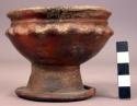 Small red pedestal pottery vessel