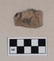 Red bodied earthenware figurine sherd, with red pigment