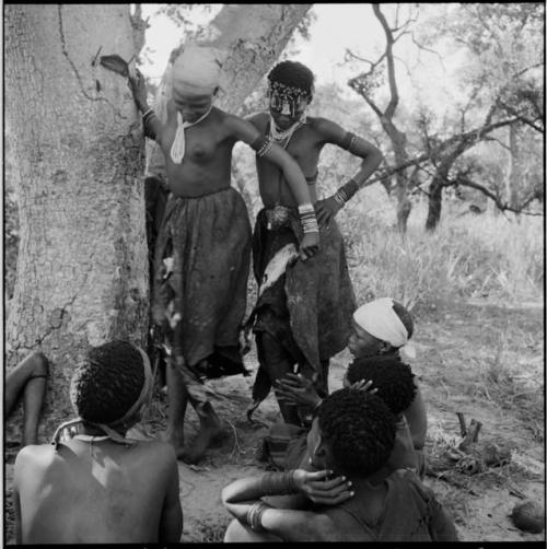 ≠Gisa and N!ai playing Tcxai Djxani (a dancing game) at a tree