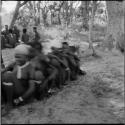 Group of women and girls playing N≠ahng !Au!uh (the snake game), sitting in a line