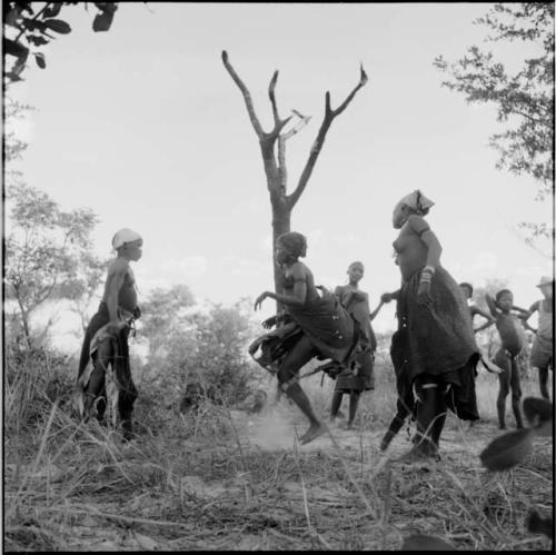 Group of women and girls playing khù n≠haru (skip-rope), with ≠Nisa and N!ai holding the rope