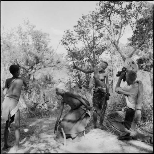 Group of women and girls playing khù n≠haru (skip-rope), with N!ai skipping, John Marshall filming them