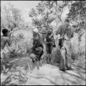 Group of women and girls playing khù n≠haru (skip-rope), with N!ai skipping, John Marshall filming them