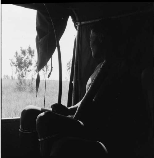 Man holding a quiver and bow, sitting inside the expedition Jeep