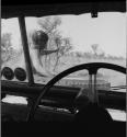 Man sitting on the front of the expedition Jeep, pointing, guiding the group to a hunting area