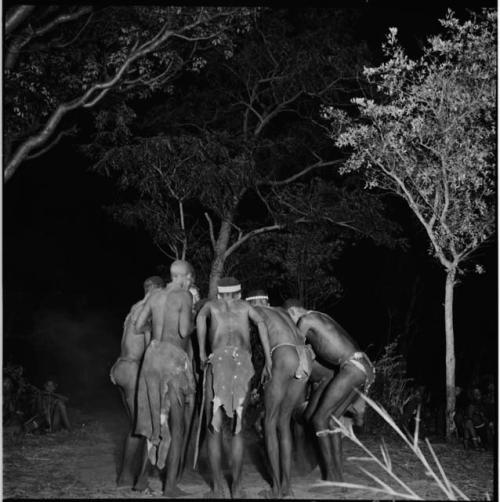 Men dancing in a circle in a night dance