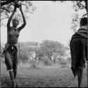 Woman catching a ball, playing tamah n!o’an (ball game) / !’hu kuitzi (veldkos game) with a group of women and girls