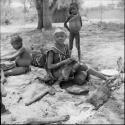 Girl sitting, with three young children behind her