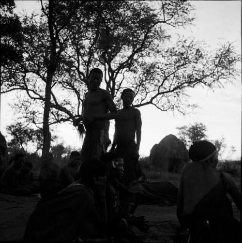 /Ti!kay dancing next to groups of people sitting at a daytime dance