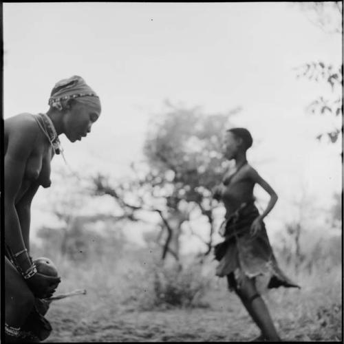 N!ai and a girl playing tamah n!o’an (ball game) / !’hu kuitzi (veldkos game) with a group of women and girls