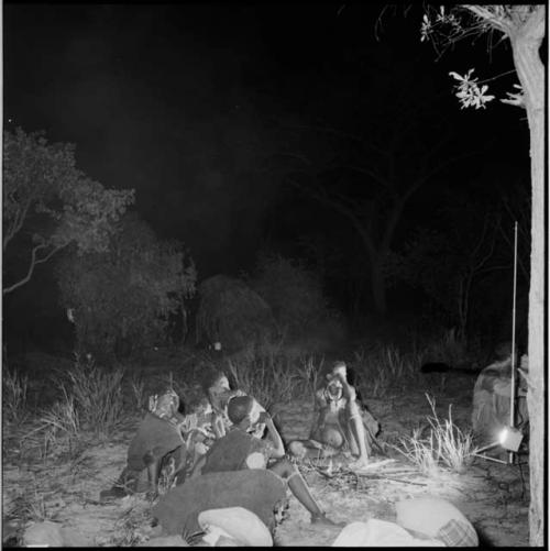 Group of women sitting, with Nicholas England standing with equipment near them