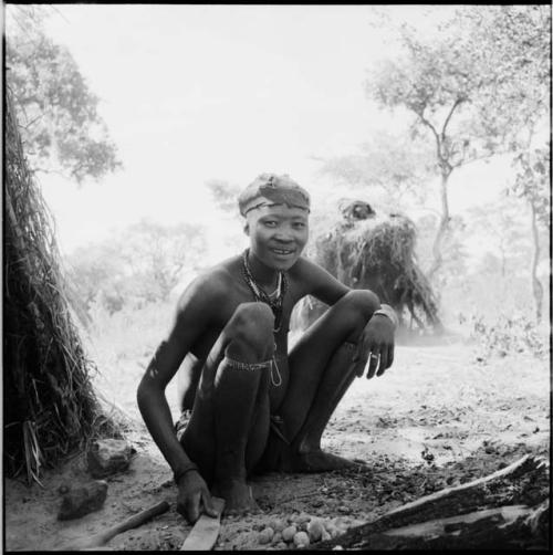 Young woman squatting next to a skerm