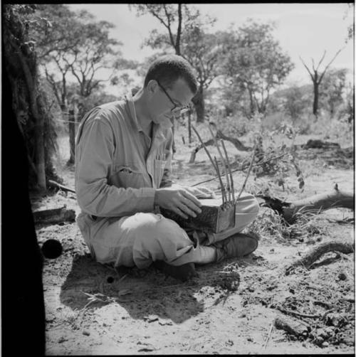 Nicholas England sitting, examining a //guashi