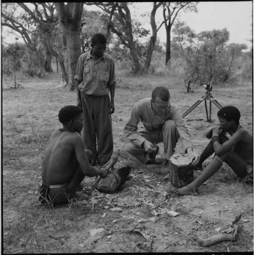 //Ao and !Naishi making a //guashi from a log, with Nicholas England and another man examining the log