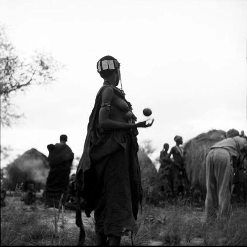 Woman playing tamah n!o’an (ball game), tossing a !’hu kuitzi (veldkos ball)