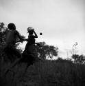 Two women playing tamah n!o’an (ball game) / !’hu kuitzi (veldkos game), dancing, with the ball in the air