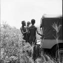 Three hunters standing at the back of the expedition Jeep