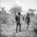 "/Gao Music" and another man going hunting, carrying their hunting equipment in their hunting sacks over their shoulders