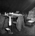 Camera and film equipment on a table inside an expedition tent