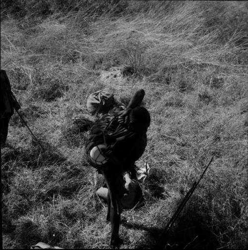 Man carrying his belongings on his back, with bags on the ground next to him