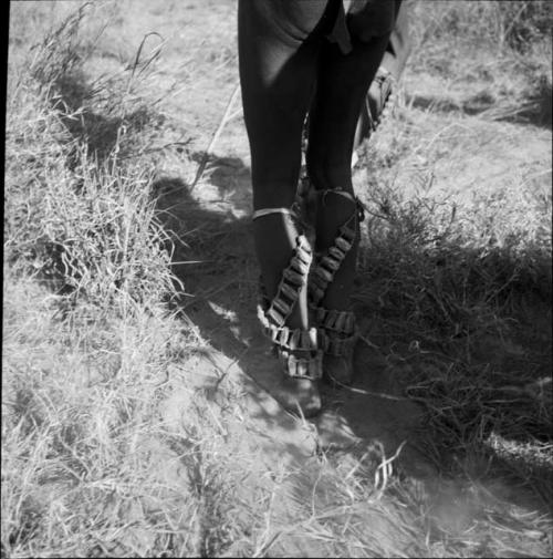 Man wearing dance rattles for a daytime dance, close-up of his legs